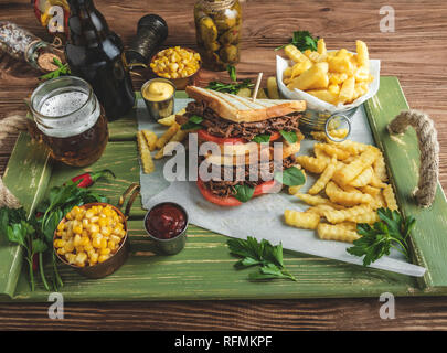 Sandwich beef pulled , barbeque, toast, french fries, sauce, corn on a wooden tray Stock Photo
