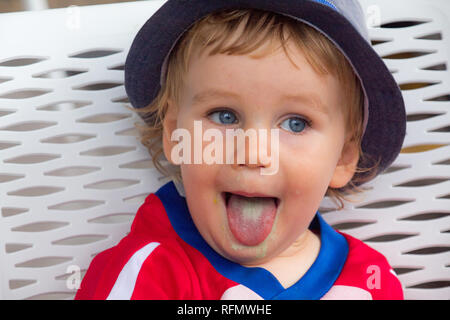 A portrait of a young boy showing tongue after having a delicious pistachio ice cream Stock Photo