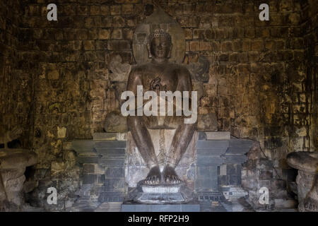 Statue of Dhyani Buddha Vairocana in the inner chamber of Mendut Buddhist temple, from the 9th century. In Borobudur, Java, Indonesia. Stock Photo