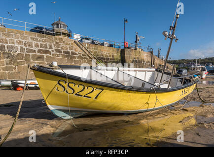 Yellow fishing boat on moorings in St.ives harbour at low tide with blue sky St.ives Cornwall UK Europe Stock Photo