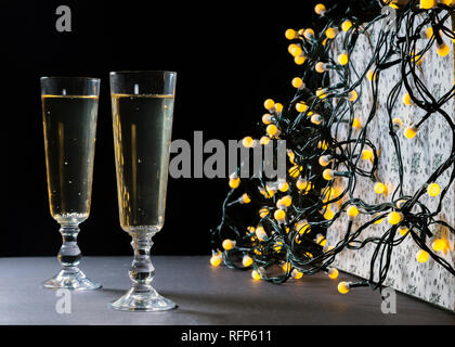 Two champagne glasses on Christmas. Defocused lights bokeh background. Romantic mood Stock Photo