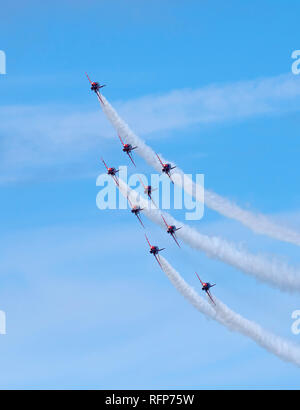 Nine aircraft of the RAF Red Arrows Display Team flying in formation, banking left and seen head-on. Stock Photo