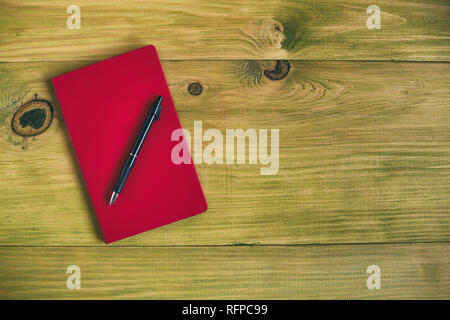 Image of personal organizer and pen wooden table.Toned photo and contains little noise because of high ISO set on camera. Stock Photo