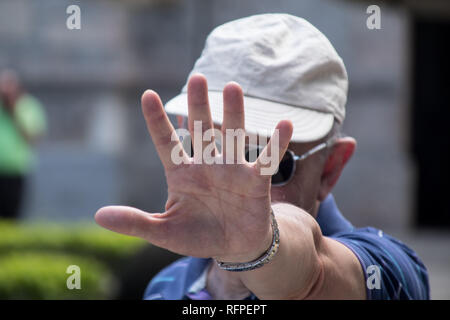 A portrait of a man that is playfully hiding his face from the camera Stock Photo
