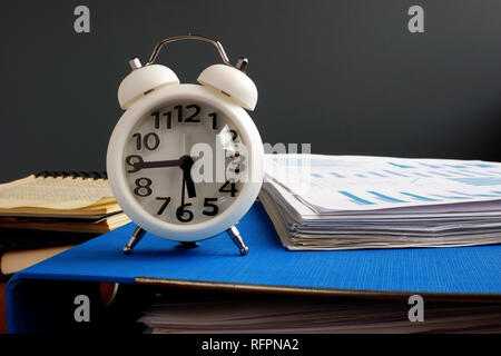 Time management. Watch and pile of documents and papers. Stock Photo