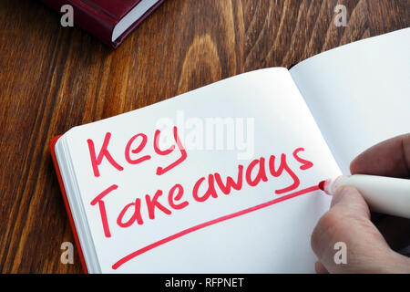 Key takeaways written by man in the note. Stock Photo