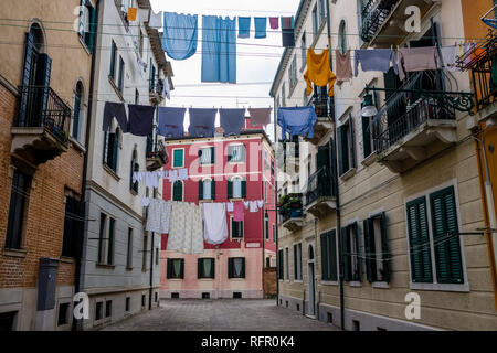 Narrow streets leading through the ailing brick houses of the so-called 'Floating city', laundry is put up on washing lines Stock Photo