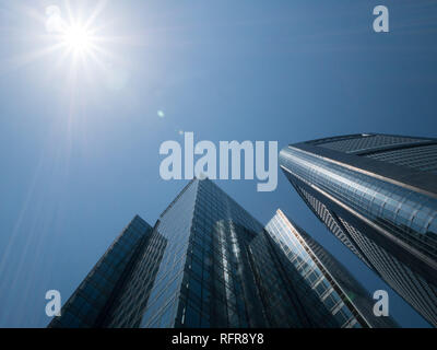 Japan, Tokyo - April 22, 2018: Skyscrapers raising up into the sky to the sun rays on a sunny day Stock Photo