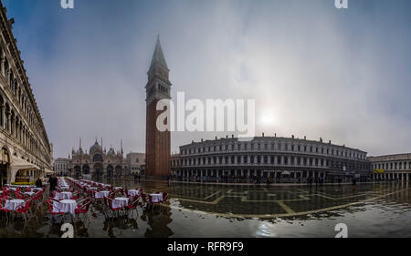 Panoramic view on San Marco Square, Piazza San Marco, with empty tables and chairs of a restaurant, flooded during the Acqua alta Stock Photo