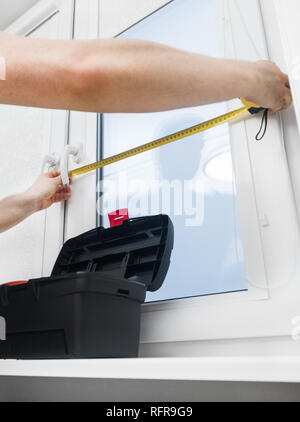 Handyman measuring window for cassette roller blinds. Stock Photo