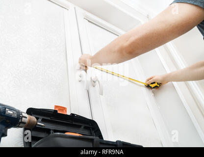 Man installing cassette roller blinds on windows Stock Photo