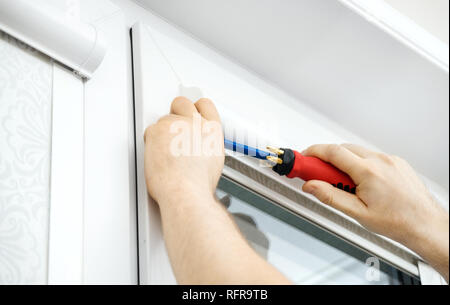 Man installing cassette roller blinds on windows Stock Photo