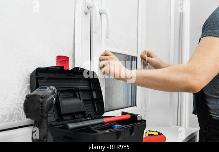 Man testing cassette roller blinds on windows. Stock Photo