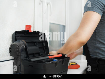 Man testing cassette roller blinds on windows. Stock Photo