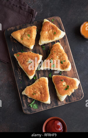 Deep fried vegetable pies, samsa, samosas, echpochmak - traditional meat stuffed pies or vegetarian pies on rustic background, copy space. Stock Photo