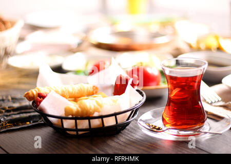 A cup of freshly-fermented tea for breakfast with bread and bread Tomato cheese on a wooden table Stock Photo