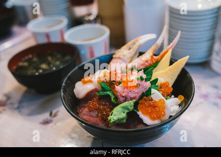 Chirashi Sushi Don or sashimi donburi, Japanese seafood rice bowl topped with mixed raw tuna fish, salmon roe, hotate scallop, engawa, crab claw meat Stock Photo