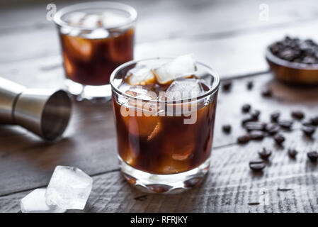 Black Russian Cocktail with Vodka and Coffee Liquor. Homemade Alcohol Boozy Black Russian drink with coffee beans on wooden background with copy space Stock Photo
