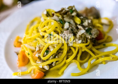 Noodles with artichokes and sea bass in Italian restaurant Stock Photo