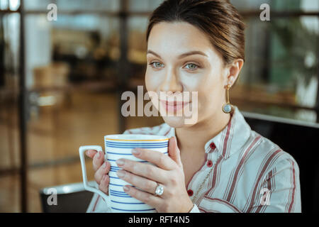 Close up of beautiful woman wearing nice jewelry drinking tea Stock Photo