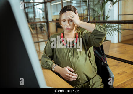 Young pregnant woman having headache after working on computer Stock Photo