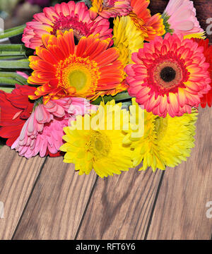Beautiful bouquet of different colorful gerberas close up on a wooden background Concept of festive or mourning design Stock Photo