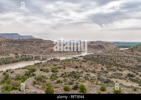 View downstream of the Vanderkloof Dam in the Orange River on the border of the Free State and Northern Cape Provinces. The single lane road bridge is Stock Photo