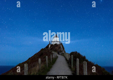 Nugget Point lighthouse under star filled sky, Kaka Point, Otago, South Island, New Zealand, Pacific Stock Photo