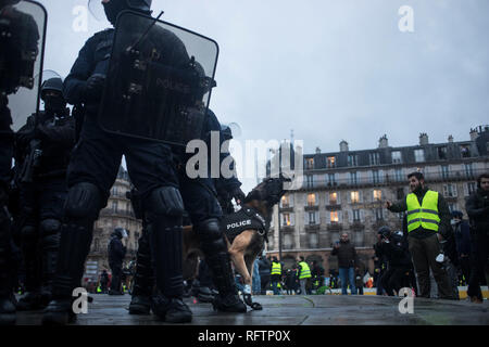A police dog is seen barking along with the riot police during a demonstration against macron policies. Yellow vest protestors gathered and march on the streets of Paris another Saturday on what they call the Act XI against the French president Emmanuel Macron policies. Stock Photo