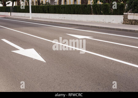 Arrow signs as road markings on a street with two lanes Stock Photo