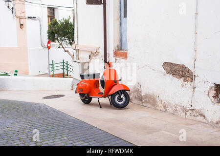 Barcelona, Spain - January 13 , 2018: Orange Scooter Vespa parked on old street in Barcelona, Spain Stock Photo