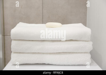Stack of white clean towels on table in bathroom Stock Photo