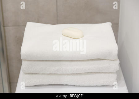 Stack of white clean towels on table in bathroom Stock Photo