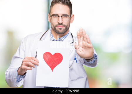 Handsome young doctor man holding paper with red heart over isolated background with open hand doing stop sign with serious and confident expression,  Stock Photo