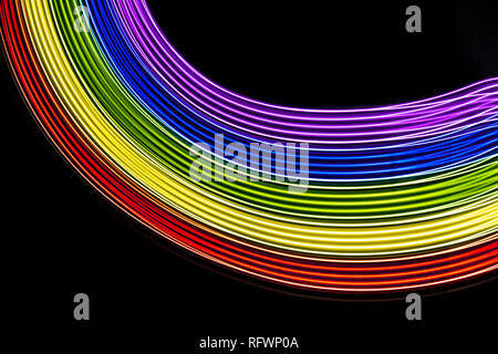 Rainbow of light. Photography made with light painting. Abstract lines with the colors of the rainbow on black background. Resource for designers. Stock Photo