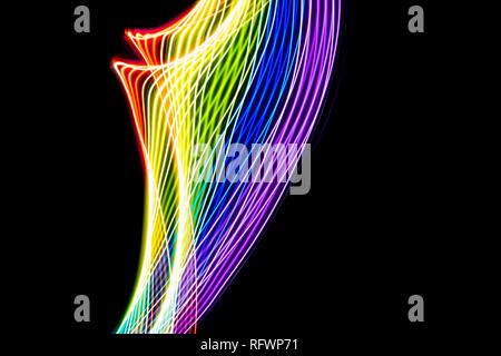 Rainbow of light. Photography made with light painting. Abstract lines with the colors of the rainbow on black background. Resource for designers. Stock Photo