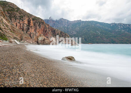 A slow exposure of waves breaking on a pebble beach in Calvi, Corsica, France, Mediterranean, Europe Stock Photo
