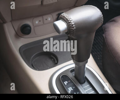 closeup of gear lever inside modern car. buttons and cup holder on background Stock Photo