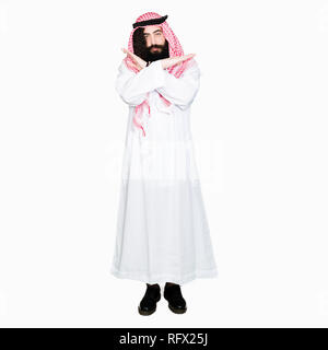 Arabian business man with long hair wearing traditional keffiyeh scarf Rejection expression crossing arms doing negative sign, angry face Stock Photo