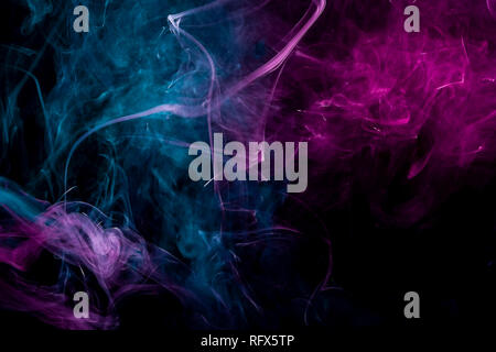 Dense multicolored smoke of   pink and blue colors on a black isolated background. Background of smoke vape Stock Photo