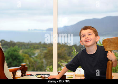 Young boy in a room with an ocean view Stock Photo