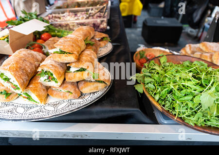 Fresh display of pile of panini bread mozzarella melted cheese sandwiches and vegetarian italian arugula in store shop cafe buffet catering Stock Photo