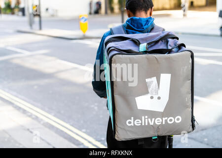 London, UK - September 13, 2018: Deliveroo backpack man with blue sign in Knightsbridge area of city during day delivering food closeup by street road Stock Photo