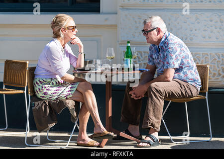 London, UK - September 13, 2018: Senior ouple man and woman sitting at table at cafe outdoor seat chairs talking and drinking wine eating in Pimlico Stock Photo