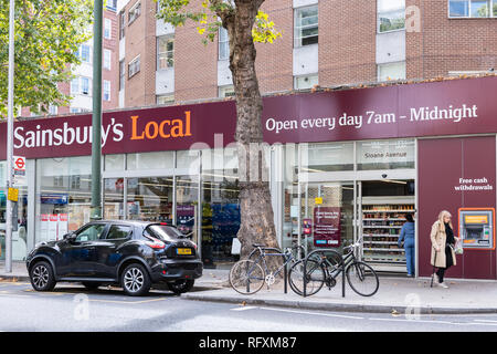 London, UK - September 16, 2018: Neighborhood store Sainsbury's local sign grocery shopping storefront facade exterior entrance with people in Chelsea Stock Photo