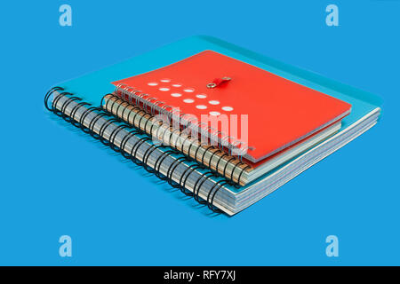 pile of notebooks on a blue background Stock Photo