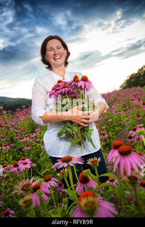 Real farmer woman in coneflower field Stock Photo