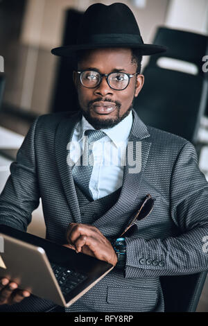 awesome pleasant man in suit is surfing the net Stock Photo