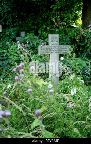 Cross headstone marking grave at Fulham Palace Road Cemetery in London Stock Photo