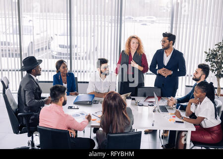 African business coach giving presentation to diverse employees group. Stock Photo